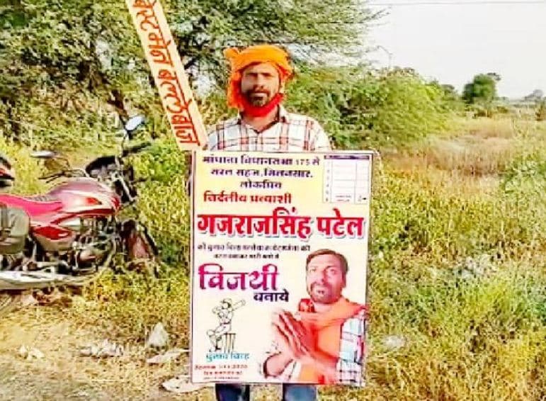 एक हाथ में बैट और एक हाथ में पोस्टर लेकर अकेले ही प्रचार में जुटा यह प्रत्याशी