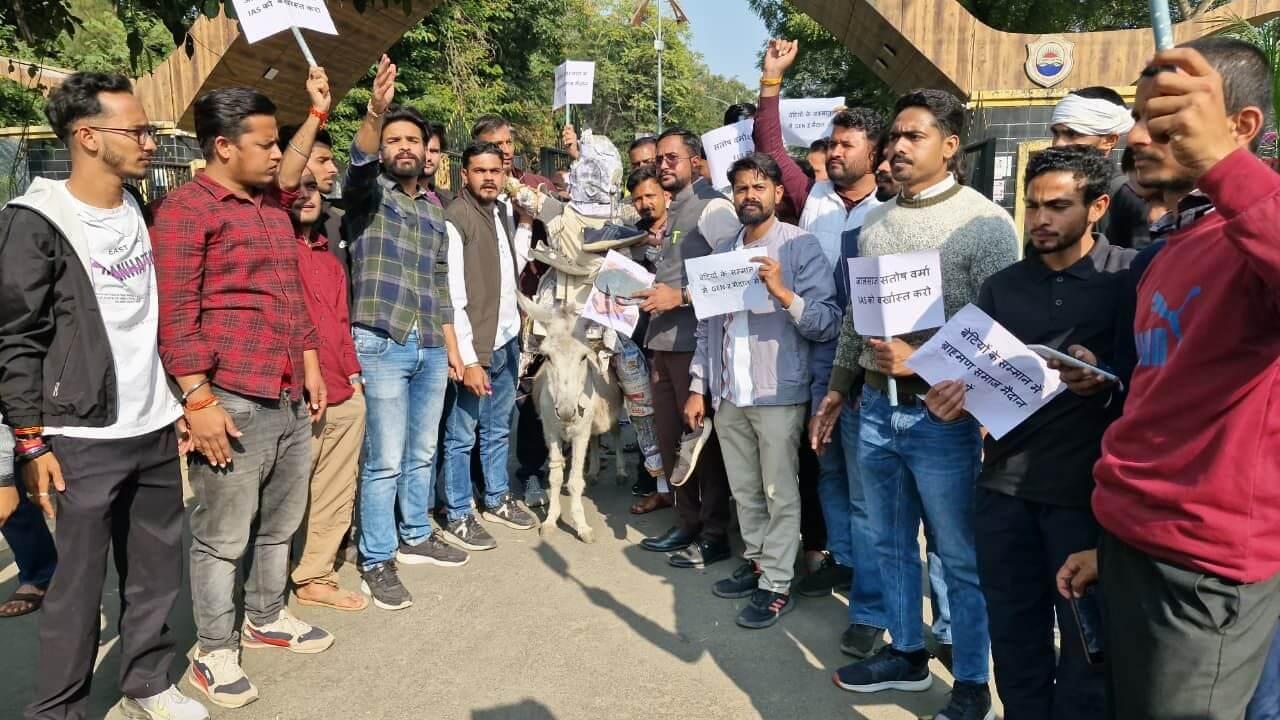 IAS संतोष वर्मा का विरोध जारी, युवाओं ने पुतले को गधे पर बैठाकर जूते-चप्पलों से की पिटाई, निलंबन व FIR की मांग